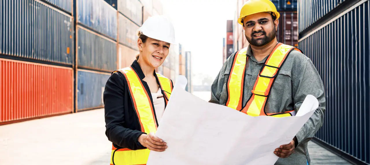 Two workers reading a construction logistics plan