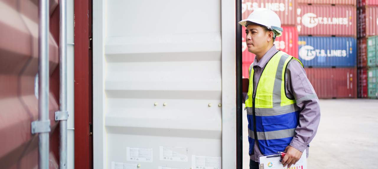 Customs officer opening a container for examination