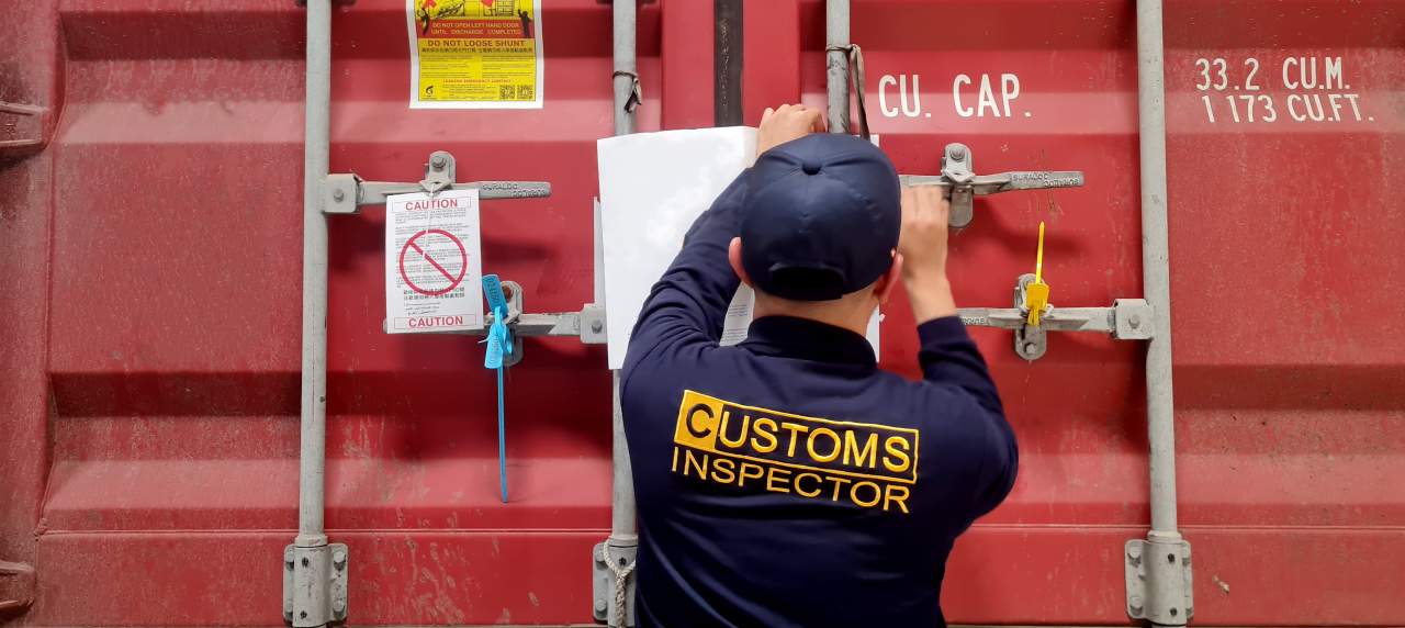 Customs officer opening shipping container for inspection